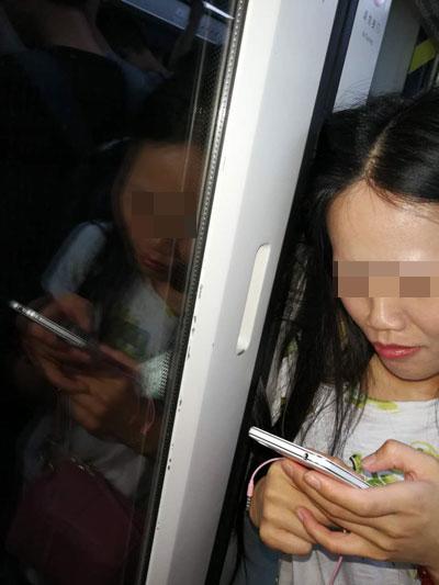 惊险!广州地铁女子头发被车门夹6站，淡定玩手机.jpg